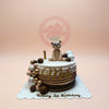 One-tier 1st birthday cake with a teddy bear, ombré brown icing, gold 'Mady' and balloon accents.