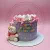 One-tier purple birthday cake with white swirls, pink bows, an edible bunny figure. Text 'HAPPY BIRTHDAY TRISHA RAIN'.