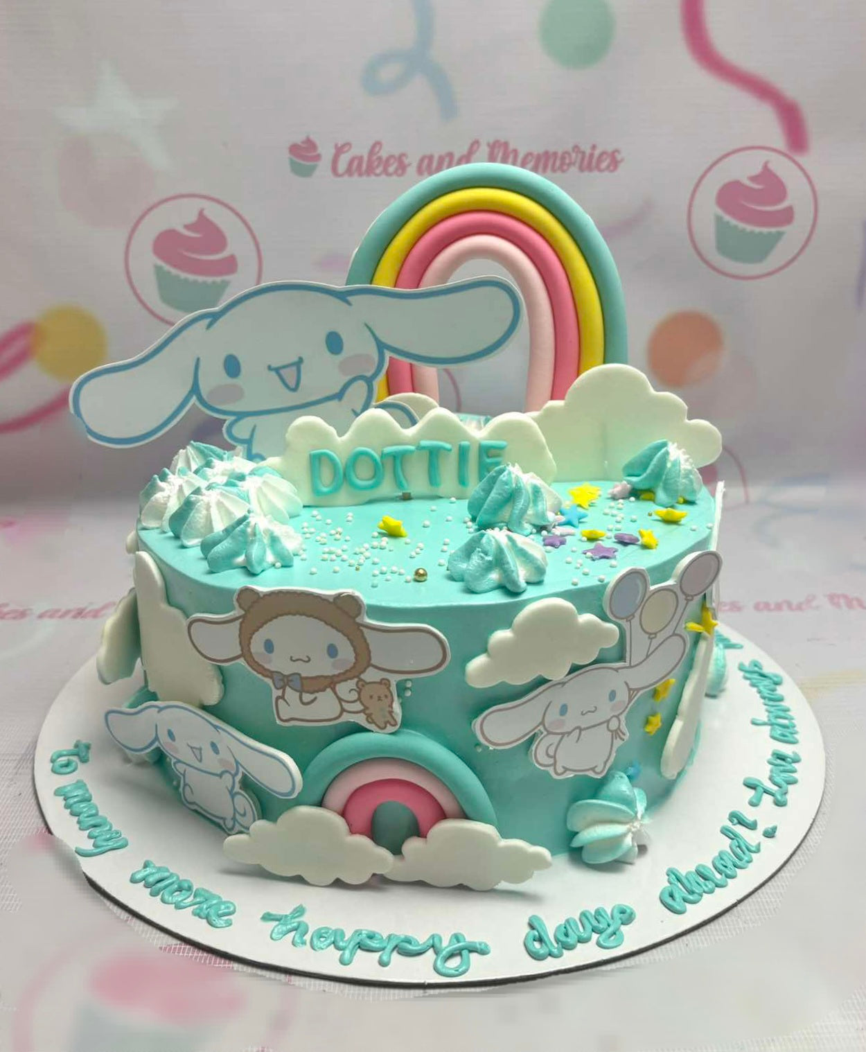 A charming Cinnamoroll Cake features a stunning teal and light blue palette, adorned with an adorable edible rainbow topper and cloud-themed printouts. Perfectly showcasing Hello Kitty and Sanrio characters, this single-layer design is a delightful treat for any cute cartoon lover.