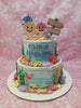This stunning two-tiered Baby Shark cake features light blue icing adorned with playful printout toppers of Baby Shark, starfish, seashells, seahorse, and coral, making it a perfect centerpiece for a birthday celebration. A cheerful 