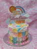 The Sunshine Cake features pastel colors and delightful decorations, including sun and rainbow motifs surrounded by fluffy cloud toppers. Perfect for a 1st birthday celebration, this charming 1-layer cake radiates happiness and captures the essence of a sunny summer morning.