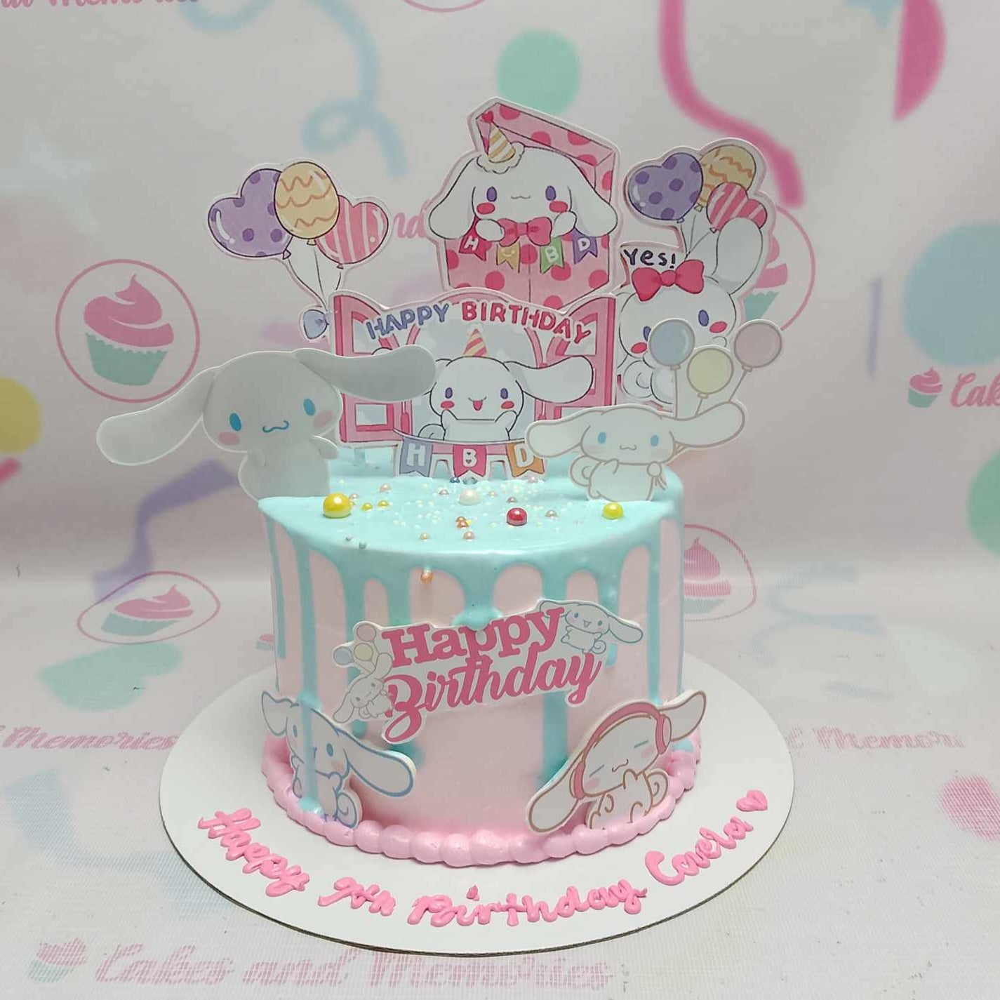 This adorable Cinnamoroll Cake features a whimsical pastel design with light pink and light blue accents, perfect for fans of Sanrio. The delightful drip cake showcases a charming 1-tier creation that celebrates Hello Kitty and friends.