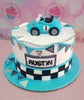 This stunning Wheels Cake features a vibrant blue and teal design with white accents, perfect for a toddler's 1st birthday celebration. Snazzy racing elements pay homage to classic cars like Ferrari and Lamborghini, making it a delightful centerpiece for any young car enthusiast's party.