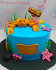 This Under the Sea Cake features a stunning blue ocean theme, adorned with an edible crab topper and starfish, perfect for celebrating Lucas' happy birthday. The one-tier design showcases charming underwater printout toppers for a delightful baby boy cake.