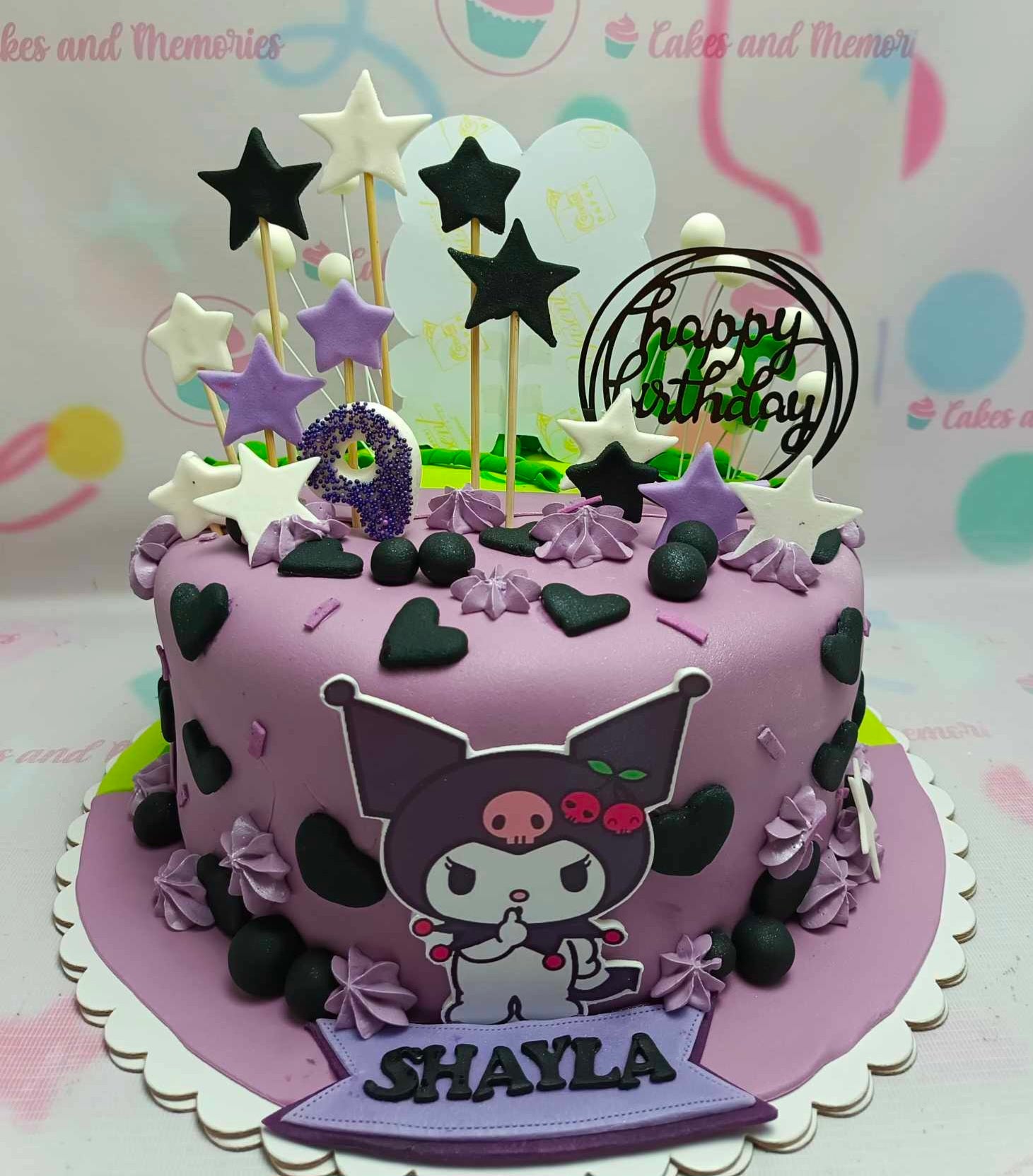 This custom Kuromi Cake features a vibrant purple and violet design adorned with black hearts and purple stars, showcasing beloved Sanrio characters like Hello Kitty and My Melody with cute printout toppers. Perfect for any celebration, this one-tier fondant cake captures the playful essence of your favorite cartoons.