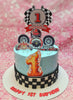This light blue racing cake features a sleek design with a black and white checkered pattern, perfect for a 1st birthday boy. Adorned with race car and Ferrari printout toppers, it showcases a fun racing theme with a steering wheel accent.