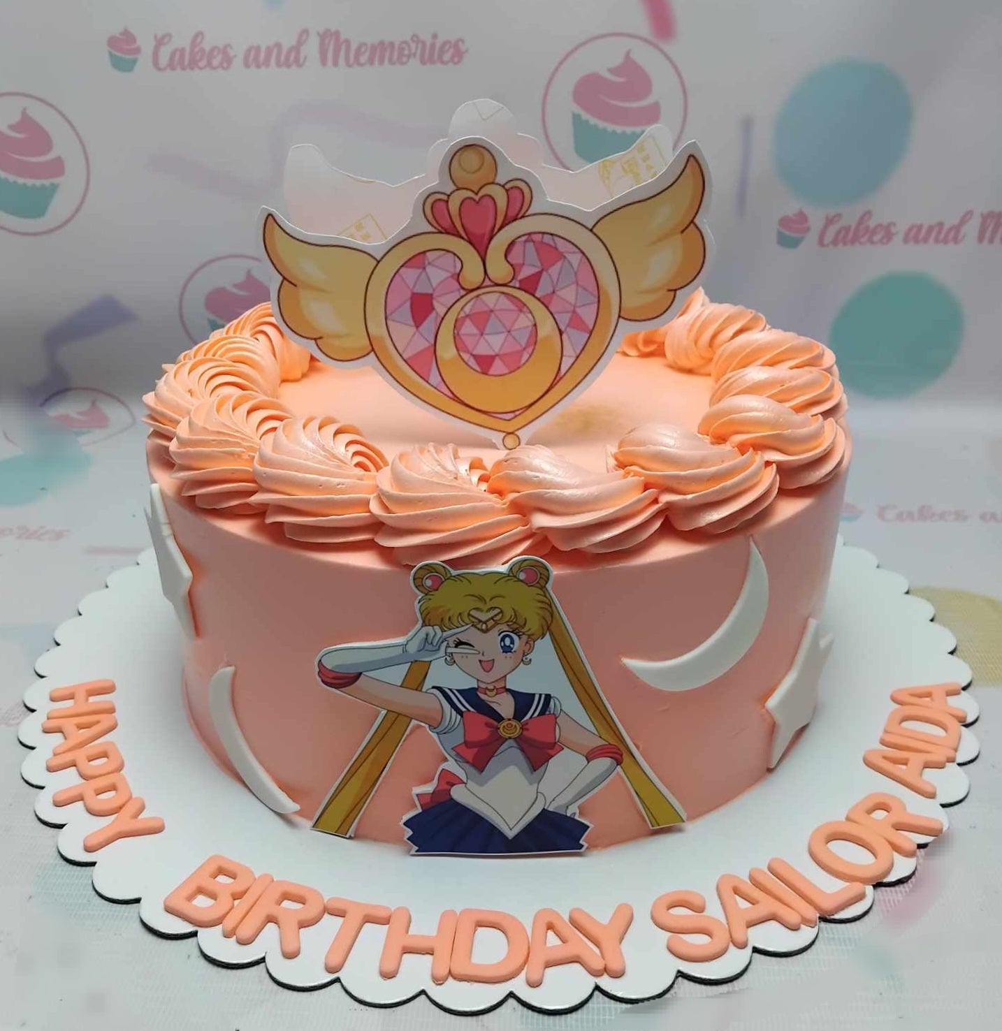 This stunning Sailor Moon Cake features a vibrant peach and pink design, showcasing beloved characters from the anime and manga, including Sailor Moon and Tuxedo Mask, adorned with colorful printout toppers. Perfect for celebrating girl power, this one-tier, one-layer treat is a must-have for any fan!