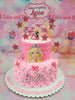 This enchanting two-tiered Barbie cake features pink soft icing frosting adorned with rosettes, gold sprinkles, and whimsical printout toppers, capturing the essence of a princess castle. Vibrant stars and hearts add a playful touch, making it the perfect centerpiece for any birthday celebration.