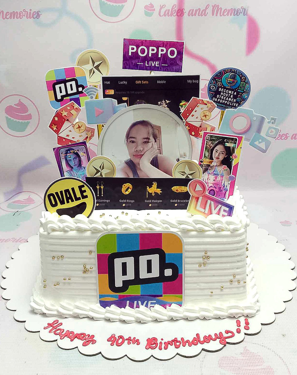 The photo features a stunning custom social media-themed cake in an oval shape, adorned with colorful printout toppers celebrating a 40th birthday. Perfect for influencers, e-girls, and online gaming enthusiasts, this cake captures the essence of digital culture with its playful design tailored for kids and adults alike.