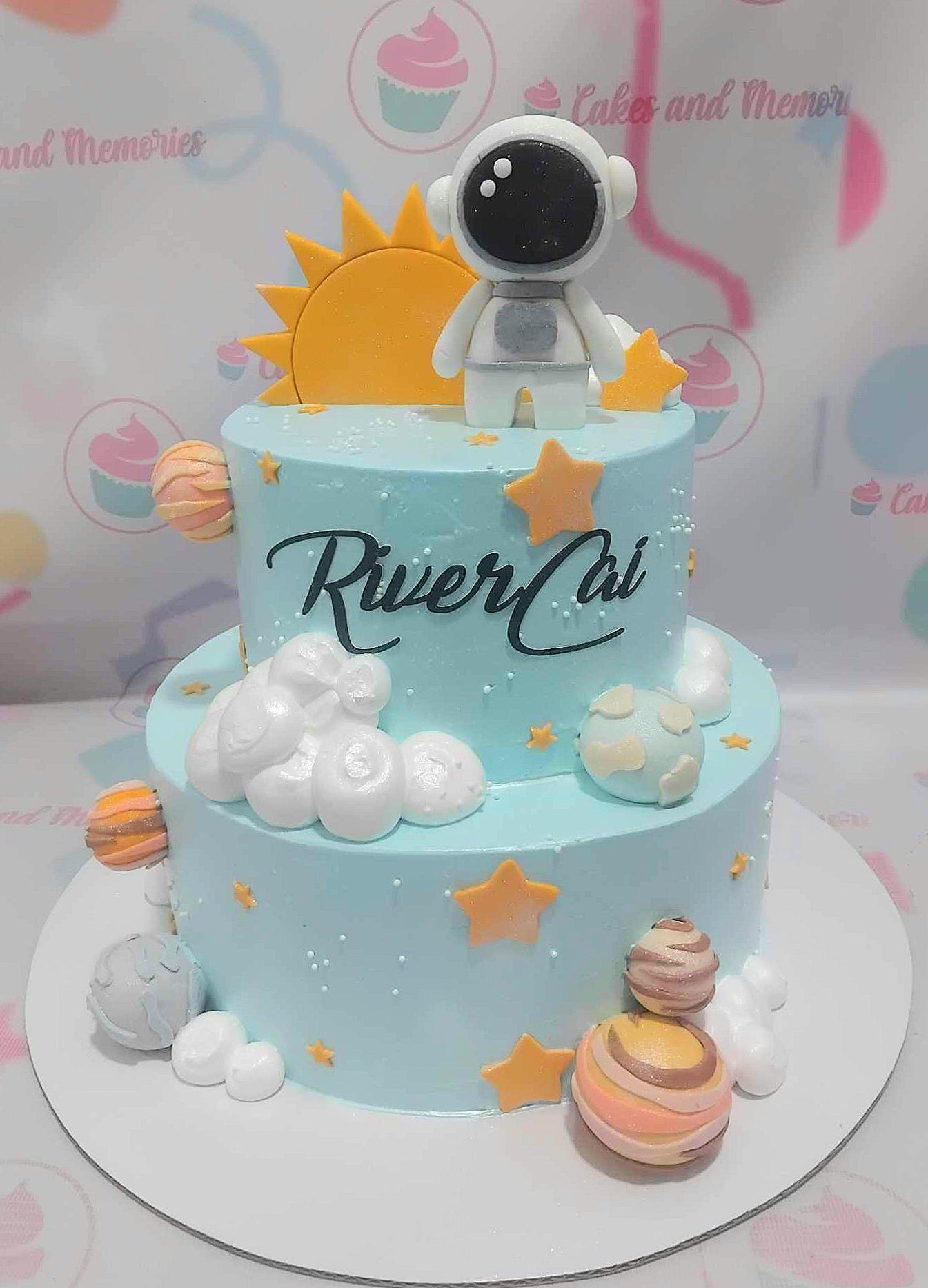 This vibrant two-tier Space Cake features a stunning blue sky adorned with fluffy clouds, planets, and twinkling stars, transporting kids to the wonders of the solar system. An adventurous astronaut stands atop, making it the perfect customized birthday cake for young space enthusiasts!