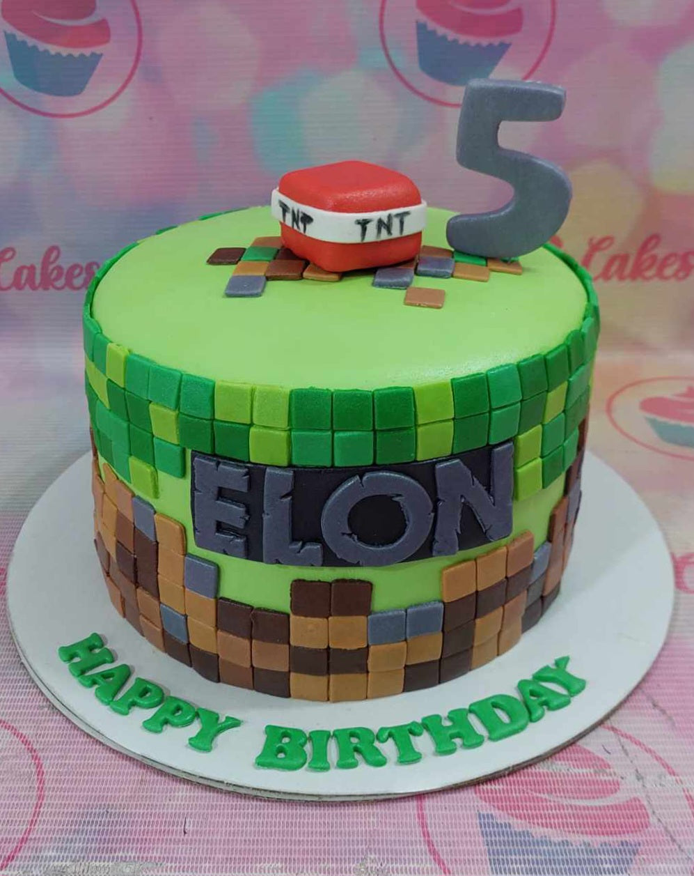 This custom Minecraft cake features a vibrant green design with pixelated blocks and a TNT motif, perfect for celebrating Elon’s 5th birthday. Adorned with printout toppers and fondant details, it captures the essence of video games for a fun-filled celebration.