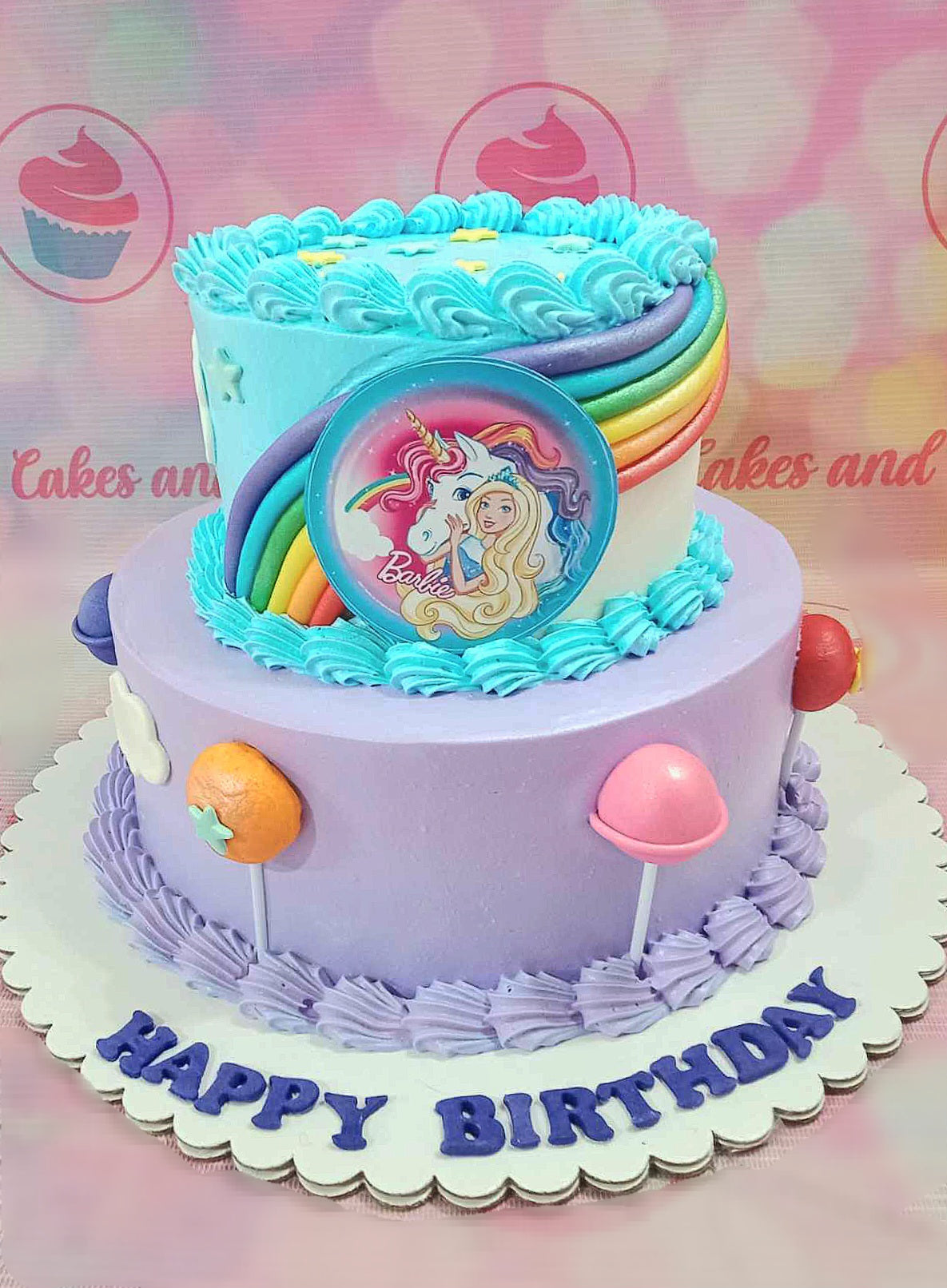 This enchanting two-tier Barbie cake features a rainbow design adorned with pastel blue and purple hues, sparkling stars, and playful lollipops, perfect for any birthday celebration. Ideal for little girls, it captures the magic of Barbie and unicorns in a delightful and colorful way.