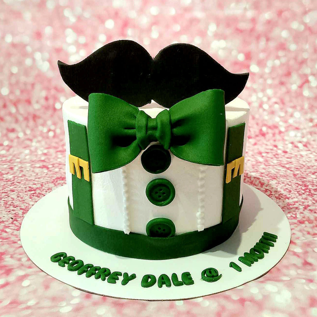 The Little Man Cake features a charming baby boy design with a fondant mustache and a green suit adorned with a bow tie, perfect for a 1st month birthday celebration. This delightful 1-tier, 1-layer cake is styled to celebrate your little man's special milestone.