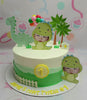 This adorable Dinosaurs Cake features a cute baby dinosaur and coconut palm trees set against a white and green backdrop. Ideal for a baby boy's first birthday, the design includes playful balloons, a fence, and “1” printout toppers atop a single tier.