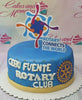 A custom Rotary Club cake features blue fondant adorned with embossed, quilted designs and the Cebu Fuente Rotary Club logo in gold. The single-tier cake is elegantly decorated with gold gears and printout toppers, showcasing the club's international spirit.