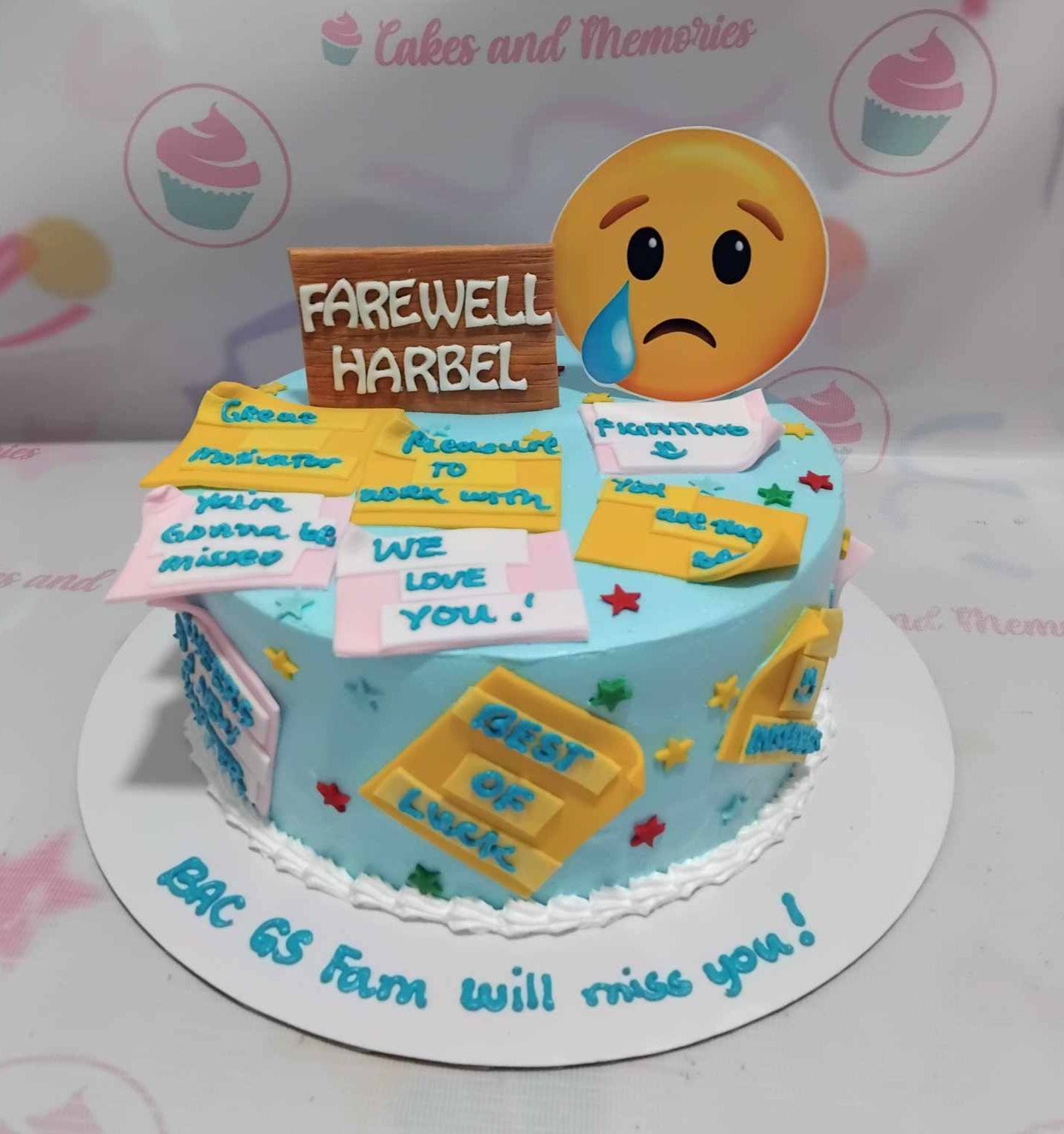 This custom 1-tier farewell cake features a vibrant blue and yellow design adorned with sad emoji motifs and playful post-it notes that read "Au revoir," "Bon voyage," and "Goodbye." Perfect for a resignation celebration, this unique cake captures the essence of a heartfelt despidida.