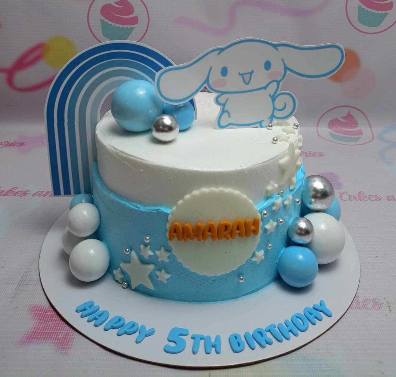 This adorable Cinnamoroll Cake features a delightful blue design adorned with Hello Kitty and friends, perfect for any celebration. With its charming rainbow accents, this single-tier, one-layer cake is sure to bring joy to any occasion.