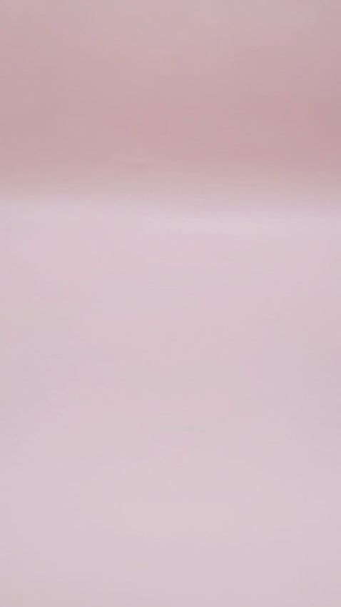 A single-tier lavender cake decorated with white piped borders, small heart accents, a red heart, and delicate white ribbons.