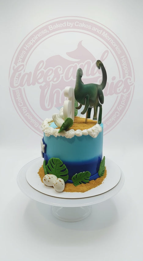 Dinosaur themed 1-tier fondant birthday cake with tropical leaves and custom name lettering
