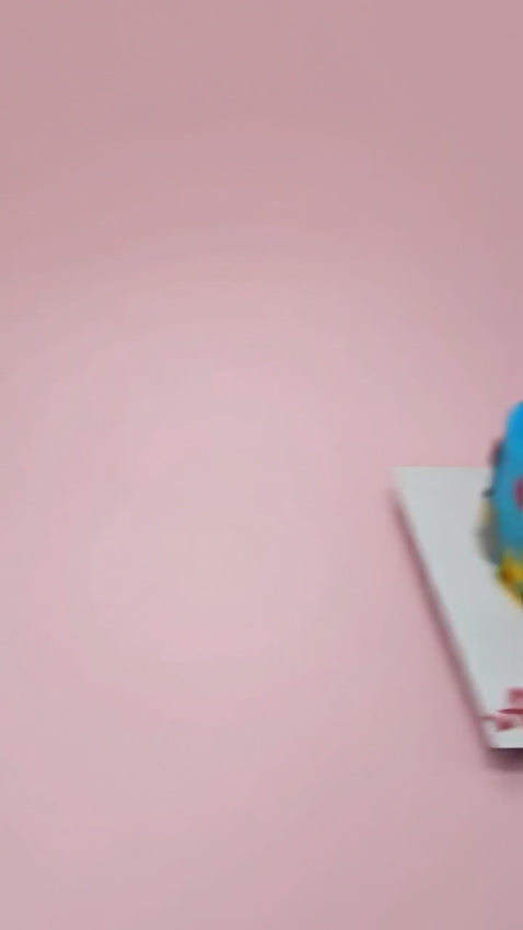 A single-tier blue Godzilla-themed cake decorated with red flames, city buildings, a number seven topper, and birthday text.