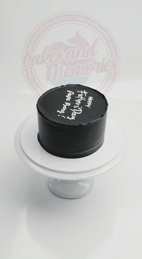 Modern minimalist 1-tier Father's Day cake with black frosting and white hand-piped lettering