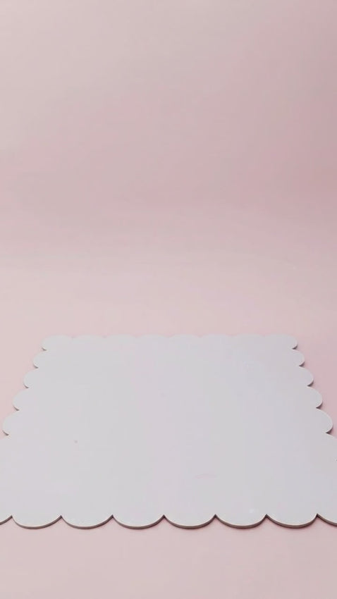 A single-tier ombre pink and white cake decorated with edible pearls and a gold glittery Shane cake topper.