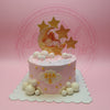 One-tier pink custom birthday cake with a sleeping girl on moon topper, golden stars, white and pink spheres, and a 