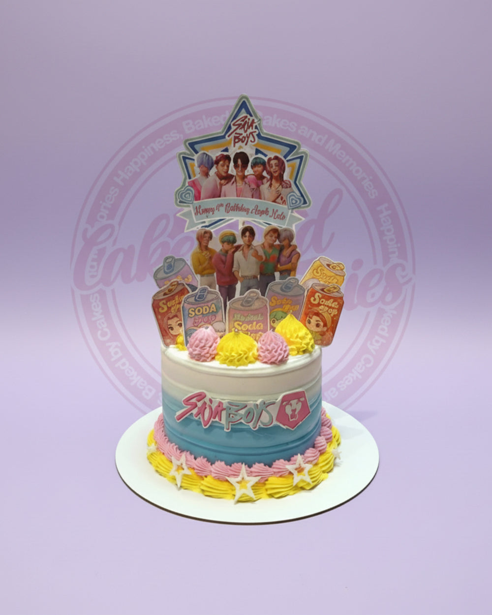 One-tier K-pop style birthday cake with 'Sia Boys' toppers and soda cans for Axl & Milo, white, blue, pink, yellow.