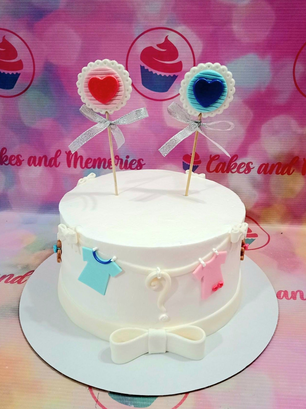 This custom decorated cake is perfect for gender reveal parties or baby showers. It features two cute baby shirts and lollipops in a blue and pink color scheme. It is sure to be a hit with your friends and family! Made with care using the highest quality ingredients, this cake will make a great addition to any gender reveal or pregnancy celebration.