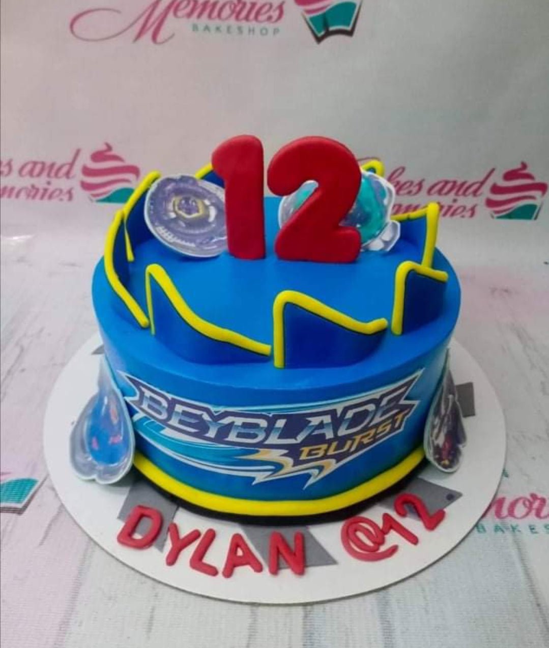 A beyblade theme cake with some amazing beyblades rolling over the top –  Creme Castle