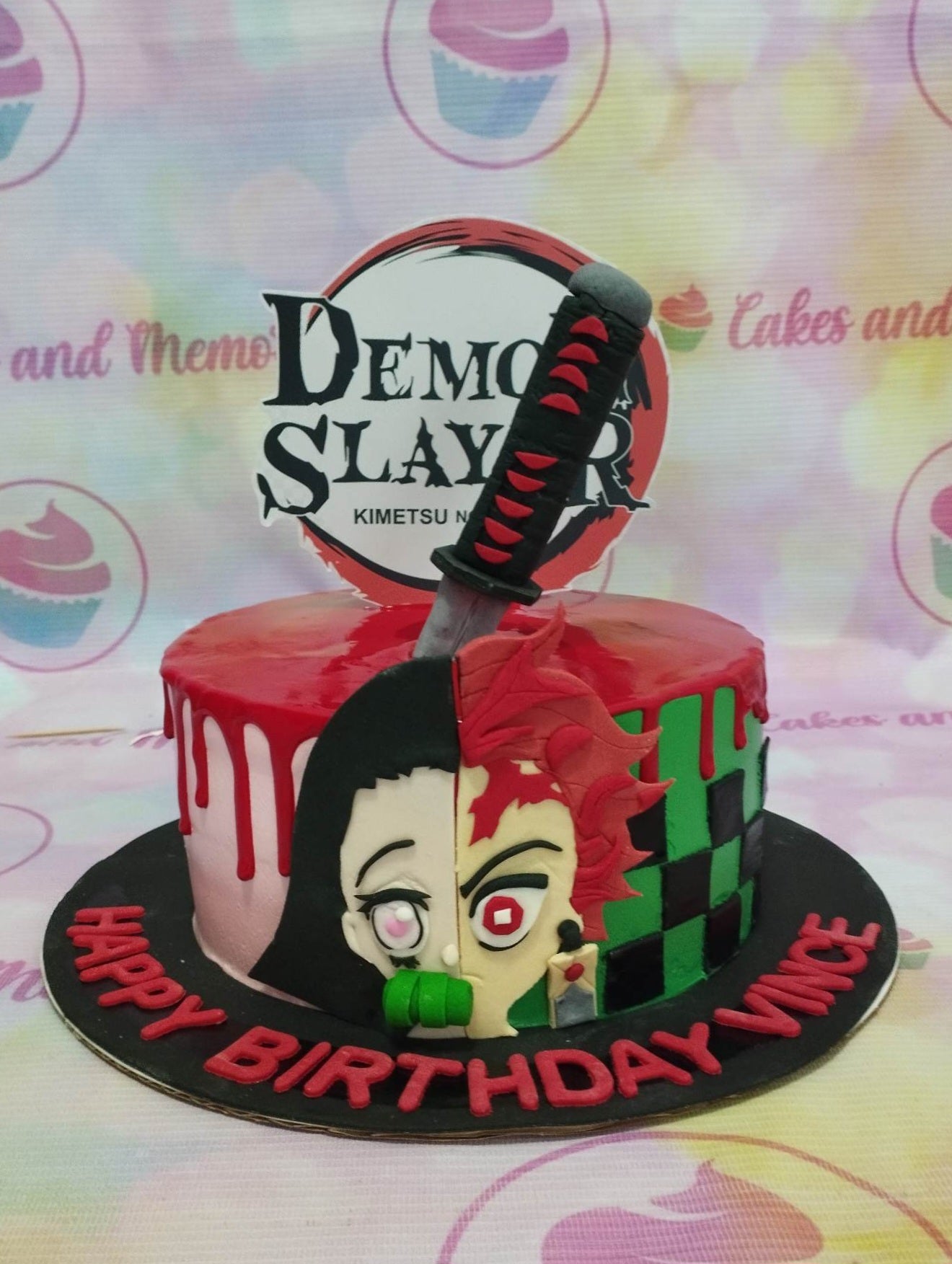This custom decorated Demon Slayer cake is sure to please any fan of the anime. It is made with layers of green and white checkered pattern and a red drip effect on the outside. The characters Tanjiro Kamado, Nezuko, Shinobu Kocho, Senitsu, and Hashibira are all featured in perfect detail on top of the cake. The cake is finished with a katana sword for the ultimate effect. Make their special day truly memorable with this personalized Demon Slayer themed birthday cake.
